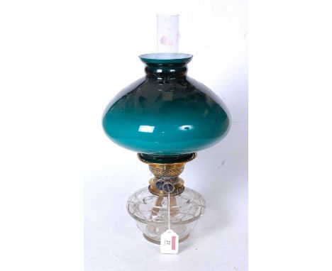 An early 20th century oil lamp, having a green opalescent glass shade, duplex burner and clear glass reservoir
