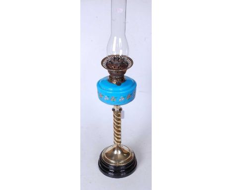 A Victorian oil lamp having a blue glass and floral enamelled font on a brass spirally turned column and platform base, heigh
