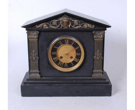 A late Victorian black slate mantel clock, of architectural form, having a matt dial with black chapter ring and Roman numera