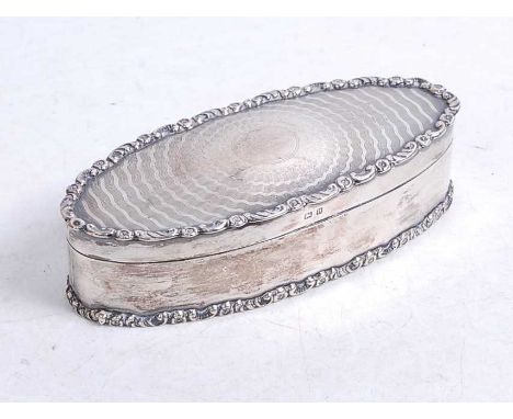 A George V silver trinket box, of oval form, with raised edge and engine turned lid, having blue felt-lined interior, interio