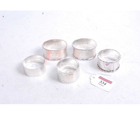 A pair of modern silver napkin rings, having engine turned decoration and initialled cartouches; together with three other va
