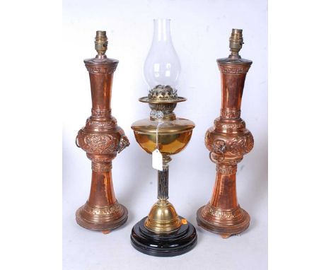 A late Victorian oil lamp having a brass font on a fluted column and domed base, 37cm,  together with a pair of large copper 