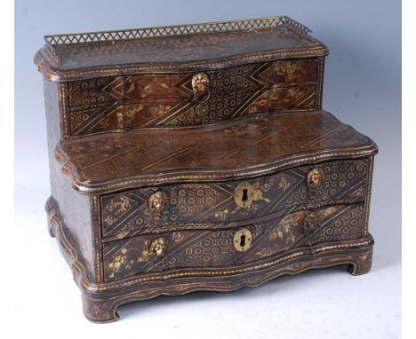 A 19th century Chinese export chinoiserie black lacquered table cabinet, of serpentine outline, having a pierced brass galler