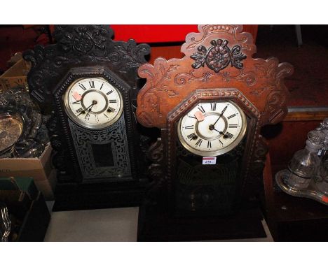 A late 19th century American walnut cased gingerbread type clock, having a painted circular dial with Roman numerals, enclose