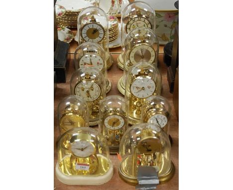 A 20th century Kundo anniversary clock having a circular dial with raised Arabic numerals under glass dome on circular base t