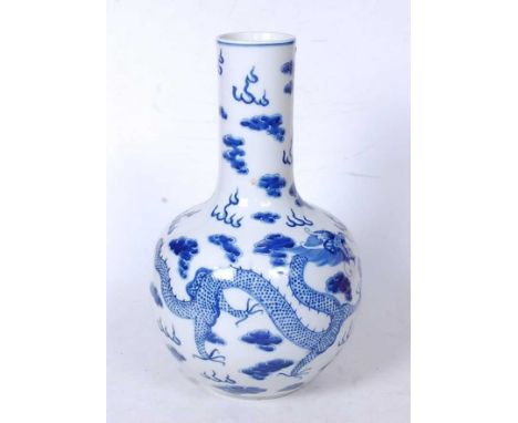 A Chinese export bottle vase, having a slender neck to a bulbous lower body, underglaze blue decorated with two dragons chasi