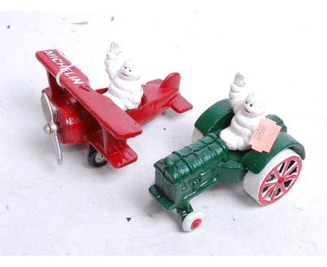 Two painted cast metal Michelin Man figures, one in a tractor, the other in an aeroplane