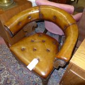 A Victorian oak library chair upholstered in tan button leather raised on turned supports W 76 D