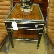 A contemporary ebonised side table of two tiers with silvered detail