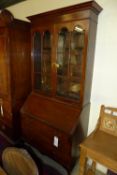 An early C20th mahogany bureau bookcase with arched glazed panel doors above fall front and