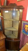 A C20th mahogany corner cabinet with glazed panel above cupboard on splayed supports