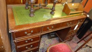 A mahogany pedestal desk the tooled leather top above arrangement of drawers