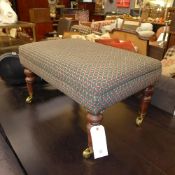A Victorian style mahogany stool with wrapover seat raised on castors