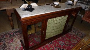 A Regency rosewood side cabinet the marble top above metal grille flanked by mirrored panel doors on