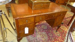 An early C20th walnut kneehole desk the tooled leather top above drawers on squat cabriole