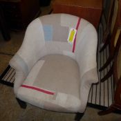 A contemporary tub chair upholstered in cream fabric