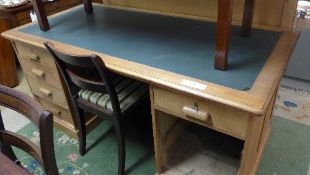 A pine pedestal desk with leather top over arrangement of drawers (no panels)
