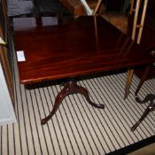 A late George III mahogany supper table the tilt top raised on baluster stem and triple supports