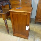 An early Victorian mahogany Miles and Edwards pedestal cabinet with a panelled door on a plinth