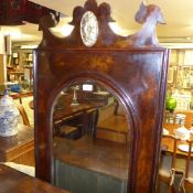 An antique walnut hall mirror the arched bevelled plate within carved crest