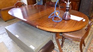 A mid C20th Danish rosewood dining table, the circular top on pedestal base extending to take two