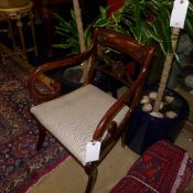 A Regency mahogany elbow chair with bar back and anthemion detail above drop in seat and scroll