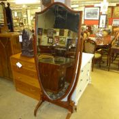 An Edwardian cheval mirror, the shield shape plate raised on boxwood strung mahogany frame