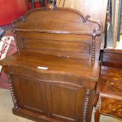 A mahogany serpentine chiffonaire with gallery back over panel doors on plinth base