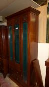 An Edwardian mahogany gun cabinet with bevelled glazed panels above drawers