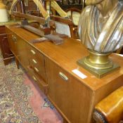 A teak Danish design sideboard with central drawers flanked by cupboards