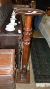 A late Victorian mahogany torchere the disc top raised on carved column