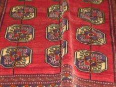 A fine old North East Persian Turkoman carpet repeating elephant foot ghoul motifs on a rouge