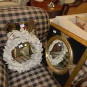 A faux marble cherub decorated mirror and two others