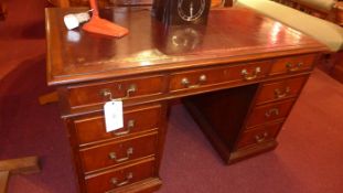 A Victorian mahogany pedestal desk the tooled leather top above arrangement of drawers with brass