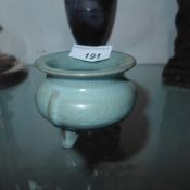 A Chinese celadon glazed incense burner raised on three supports