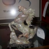 A Chinese carved soapstone figure of a horse raised on a carved base