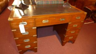 A Campaign style mahogany and brass bound pedestal desk the tooled leather top above arrangement