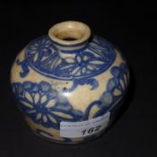 A Chinese Ming period squat form water pot decorated with flowers