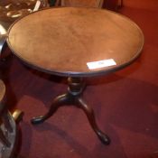 A Georgian mahogany occasional table the circular dish top raised on turned column and trform