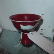 A Chinese stem bowl with white decoration on a red ground