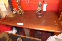 An Art Deco style teak side table raised on pedestal supports