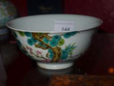 A Chinese white glazed bowl decorated with trees and blossom