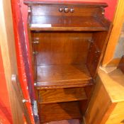An oak open bookcase of narrow proportions