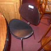 A set of four contemporary designer chairs with curved backs and black leather upholstered seats.