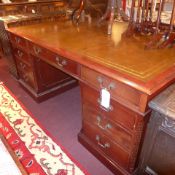 A mahogany pedestal partners desk the tooled leather lined top above arrangement of drawers to