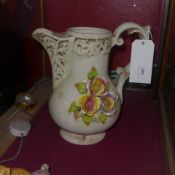 A white glazed water jug of large size decorated with flowers in relief