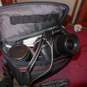 A Canon SLR camera with additional lens and accessories in case