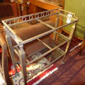 A set of gold painted and glass shelves of three tier on tapering supports