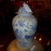 A pair of Chinese blue and white lidded temple jars decorated with fish and water lilies