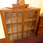 A 1930s walnut bookcase with pair of glazed panel doors enclosing shelves